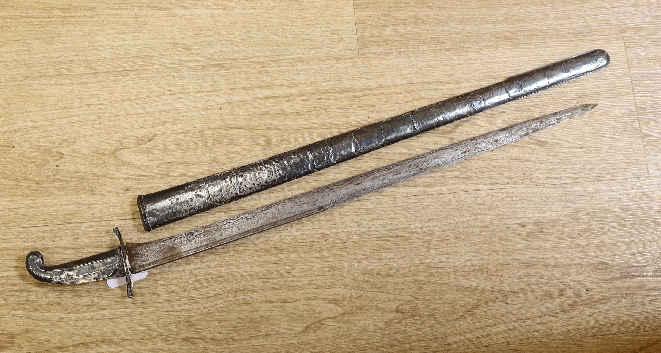 A South East Asian sword with white metal overlaid scabbard and handle, possibly Indonesian, total length 70cm